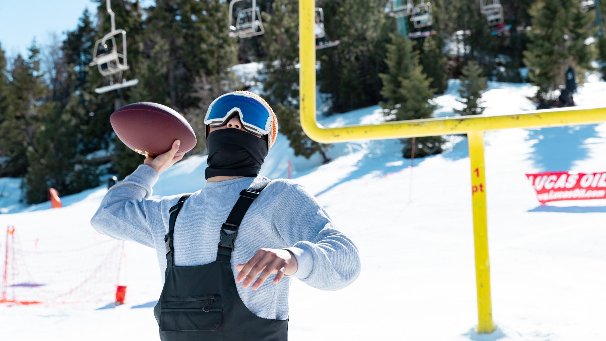 Snowboarder throwing a football
