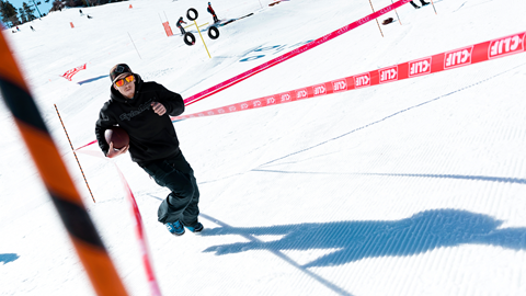 guy running through a relay race. ourse in the snow holding a football