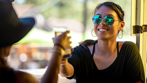 Two females cheering their beer tasting glasses