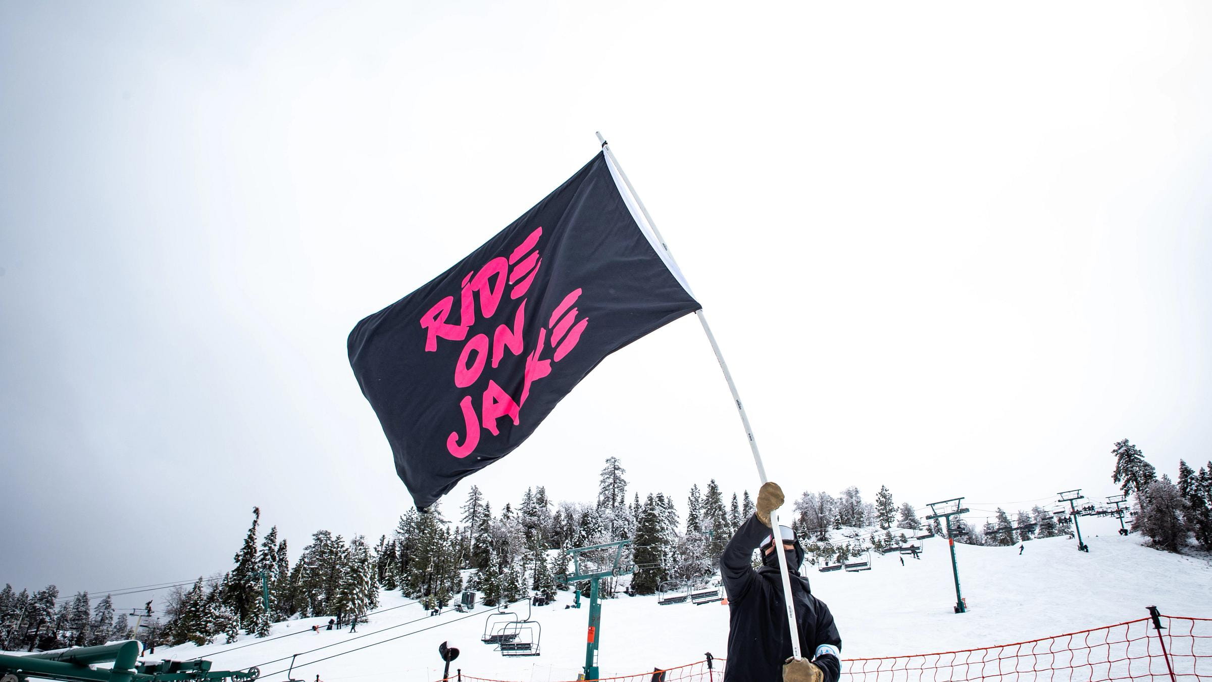 snowboarder holding a da for jake flag