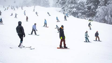Snowboarders and skiers at standstill on hill at Bear Mountain