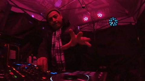 DJ Slipmatt performing a live set at a night event for Big Bear Mountain Resort underneath a canopy with stringed lights.