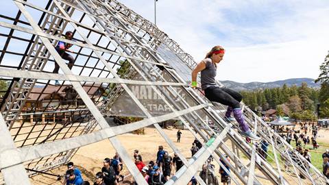 Spartan race group climbing down a rail