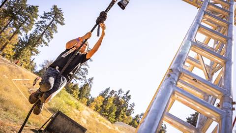 person climbing on rope at spartan race