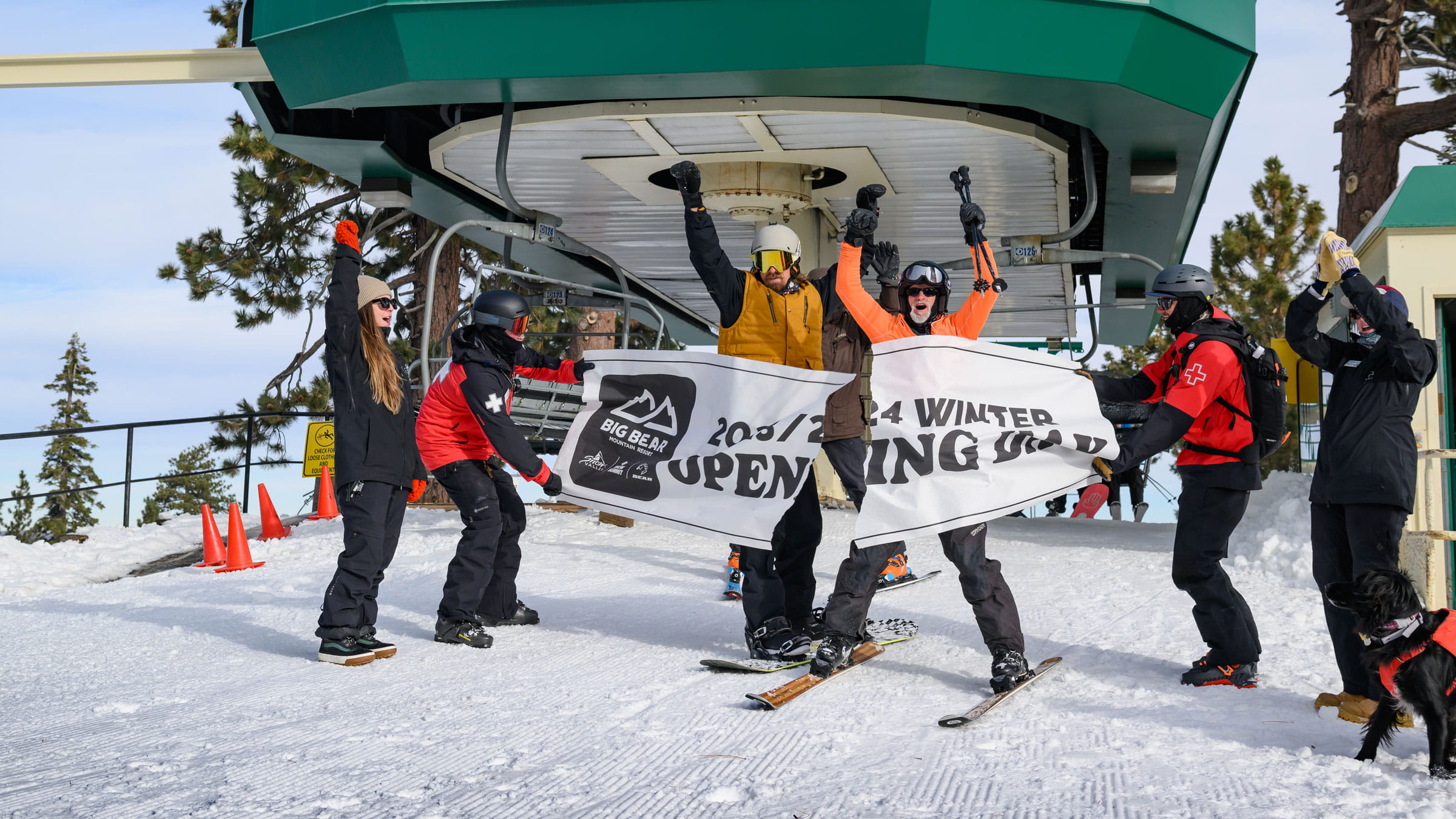 Opening Day at Snow Summit, skiers going through the first chair banner