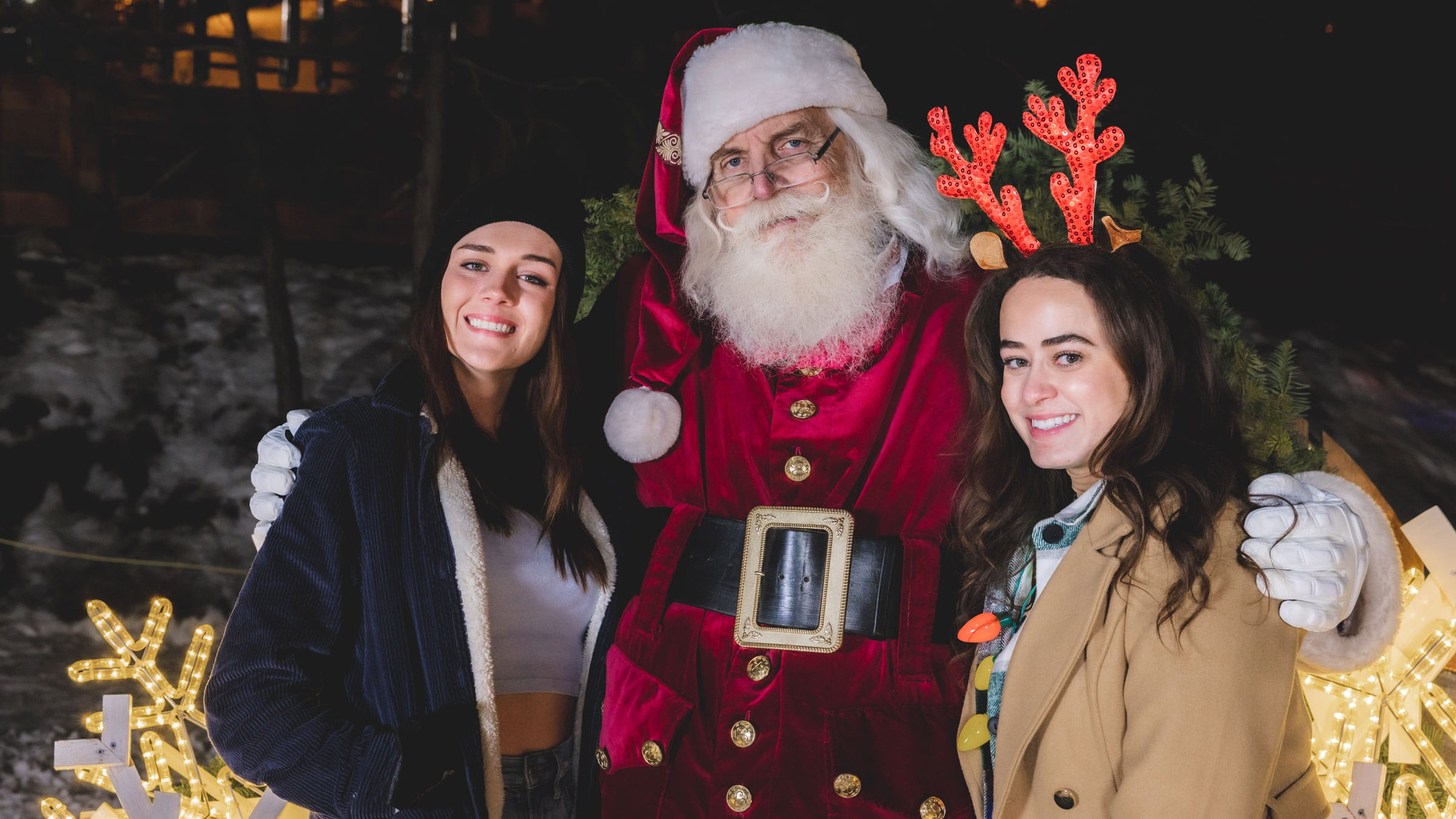 Santa taking a photo with two young females