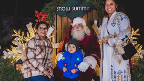 Santa taking a photo with two ladies and a child