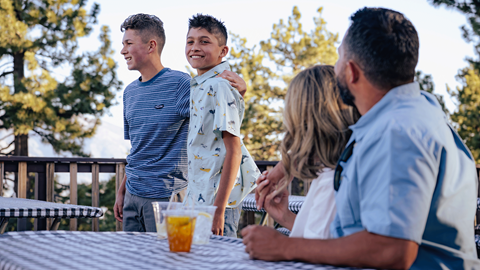 Mom and dad staring at two sons, who are watching a band during Skyline at Sundown at Snow Summit in the summer