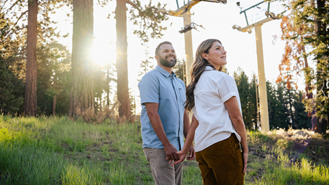 Couple holding hands in the forest during Skyline at Sundown at Snow Summit in the summer