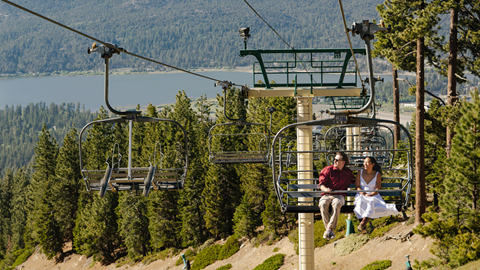 Couple riding the Scenic Sky Chair to head to the Skyline at Sundown at Snow Summit in the summer
