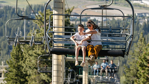 Mom and son riding the Scenic Sky Chair to head to the Skyline at Sundown at Snow Summit in the summer