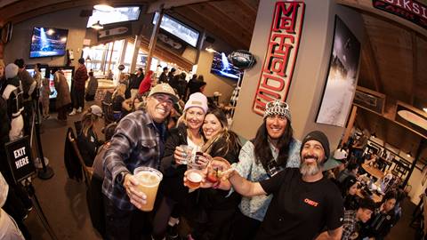 A group of adults cheersing their beverages at the Super Sunday Viewing Party at Bear Mountain's Methods Sports Bar & Coffee venue.