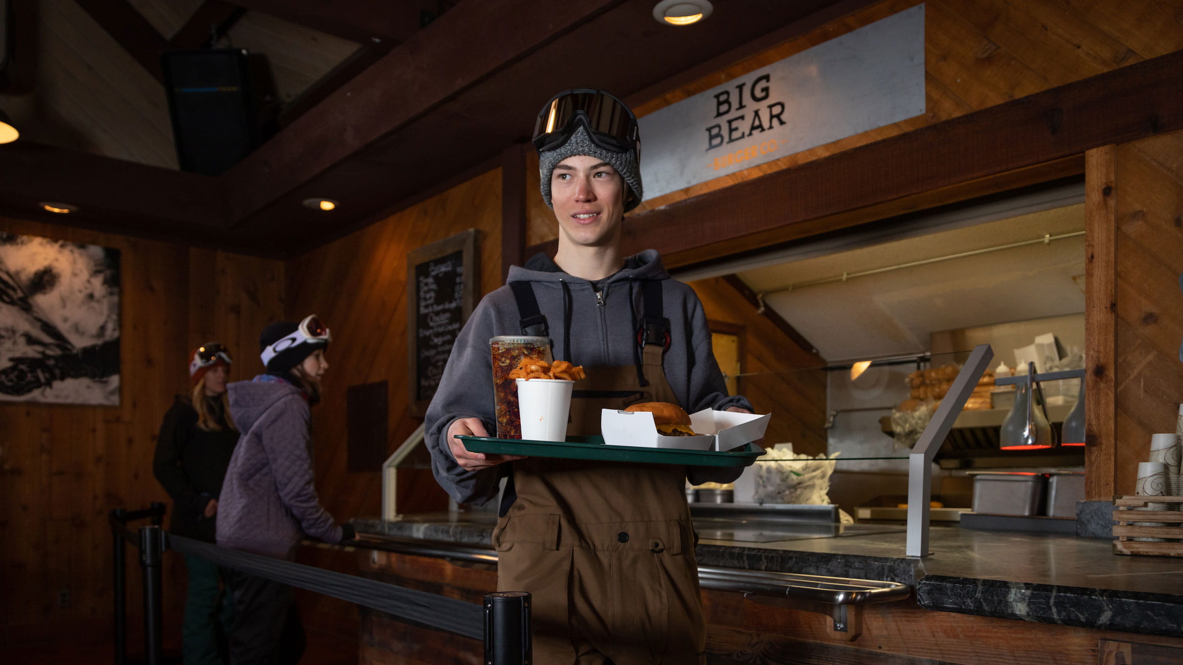 Young snowboarder carrying a plate of food