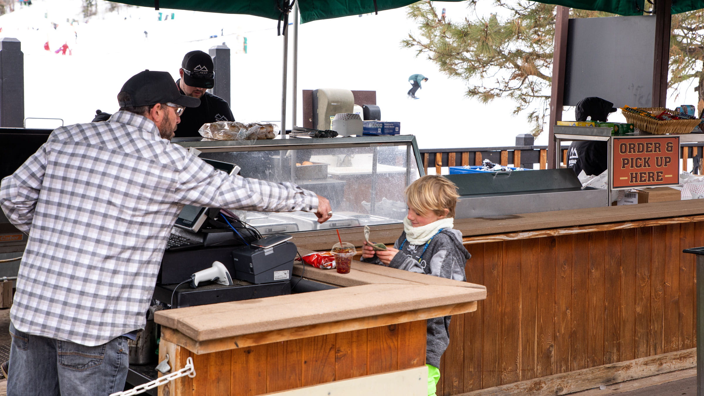 Employee handing a young child money back after purchasing some food