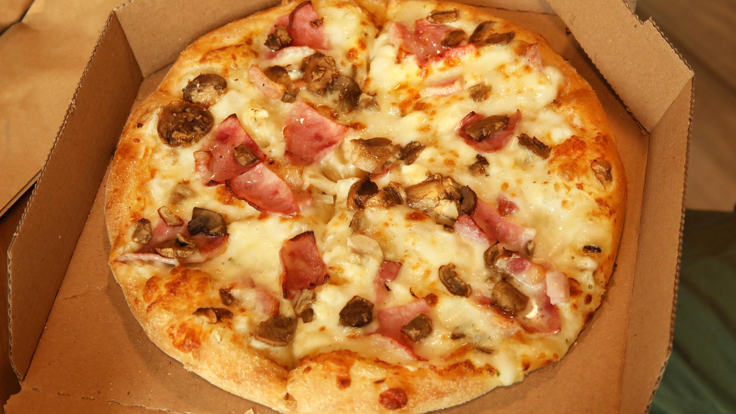 Freshly baked delivery pizza close up in plain open box