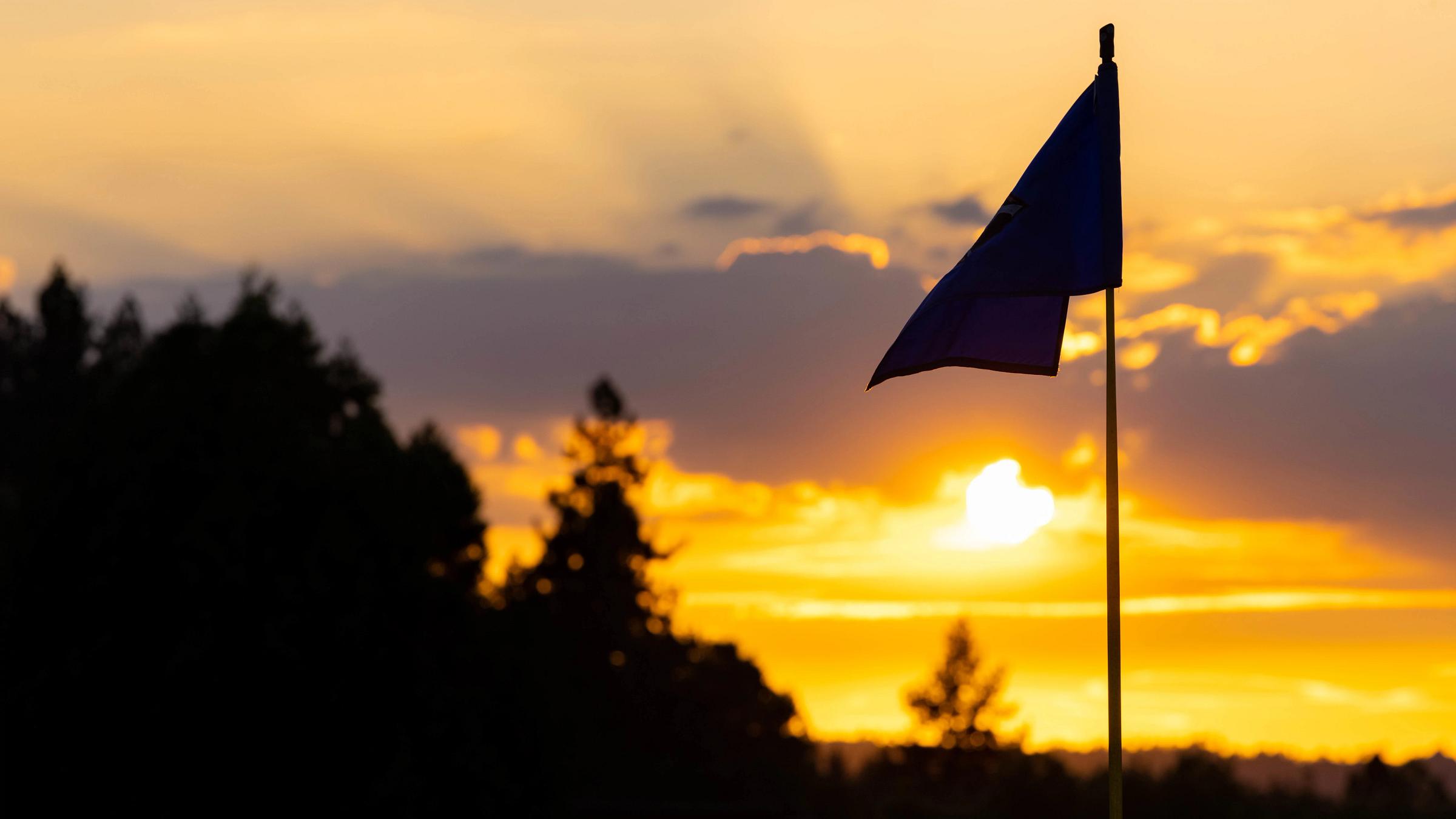Flag silhouette against a sunset sky