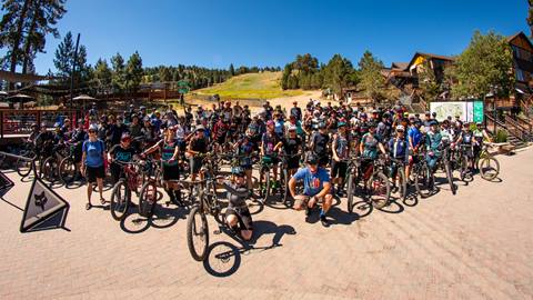 group photo of mountain bikers at summit bike park posing for a group photo in the base area