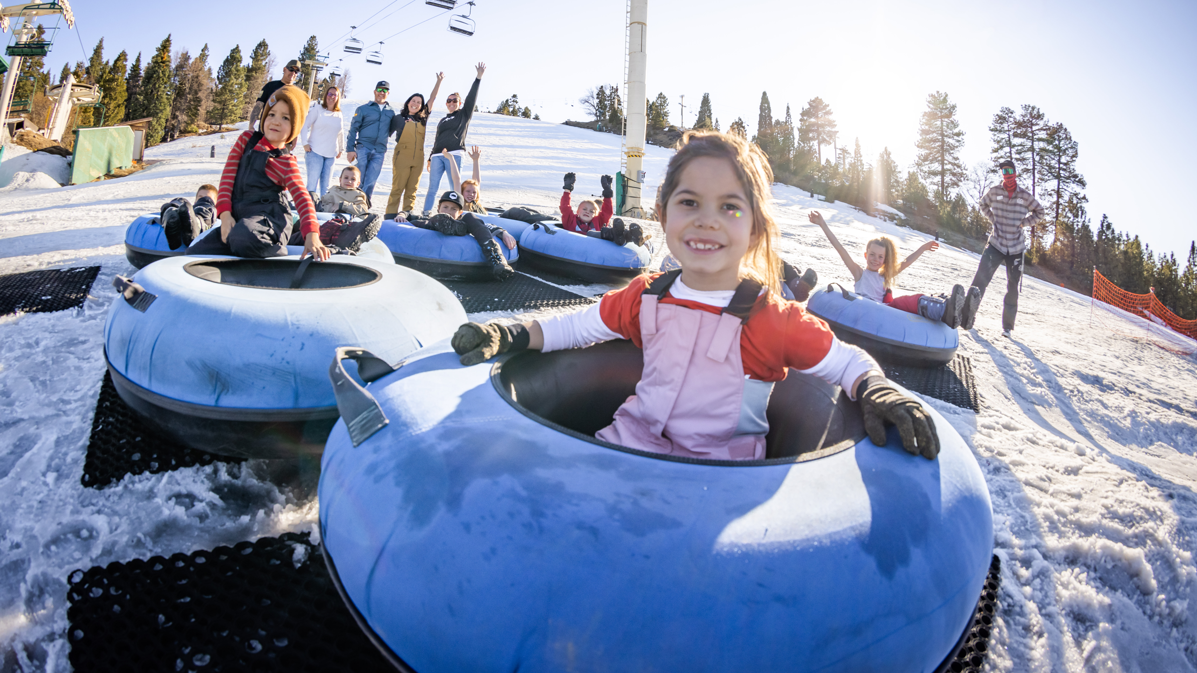 group of kids and adults in the winter time in snow tubes at snow summit