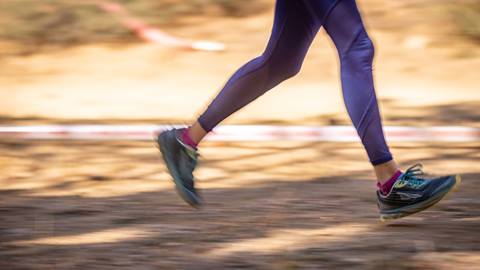 female wearing purple pants running, you only see the lower half of the body