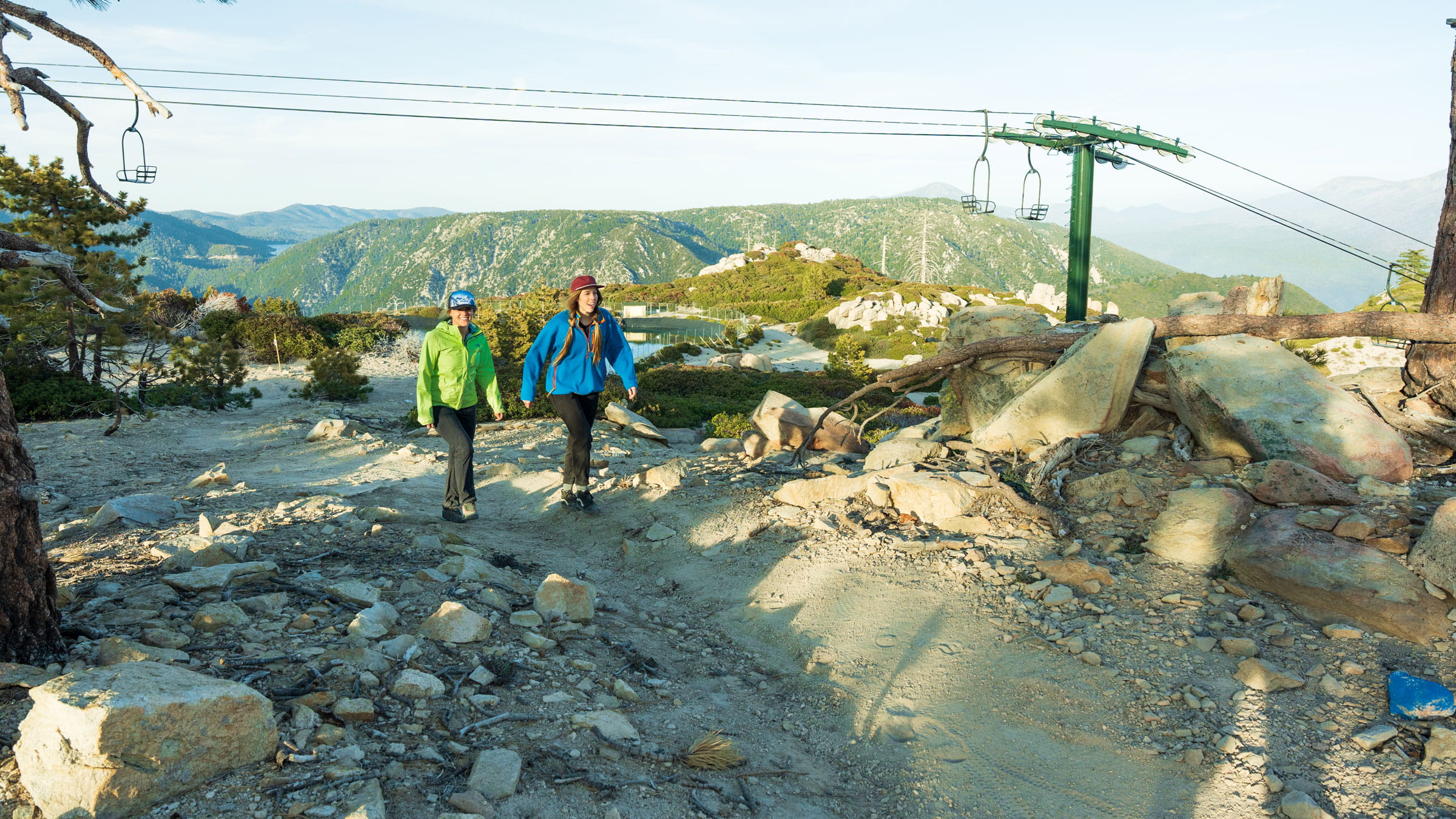 Two females at the top of snow valley in the summer on a dirt hiking trail