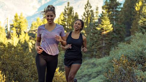 two females running on a hike in the forest