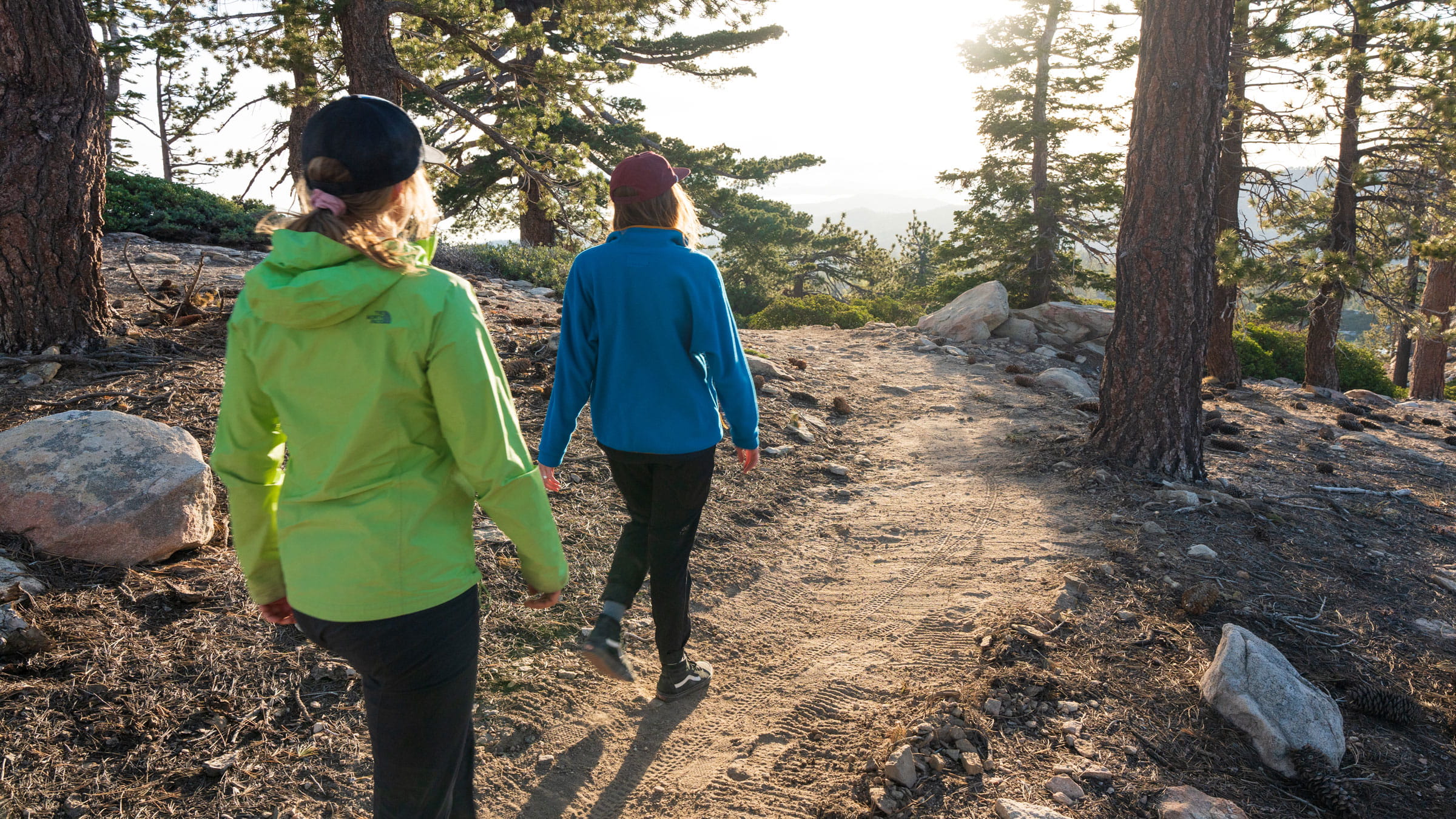 Two female hikers at snow valley in the forest on a trail