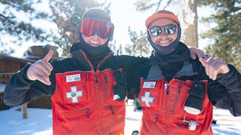 Two patrol staff smiling at the camera with their red gear on