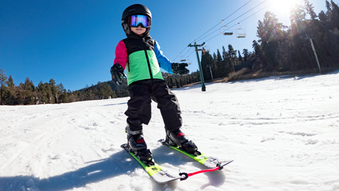 young skier going downhill on a ski slope