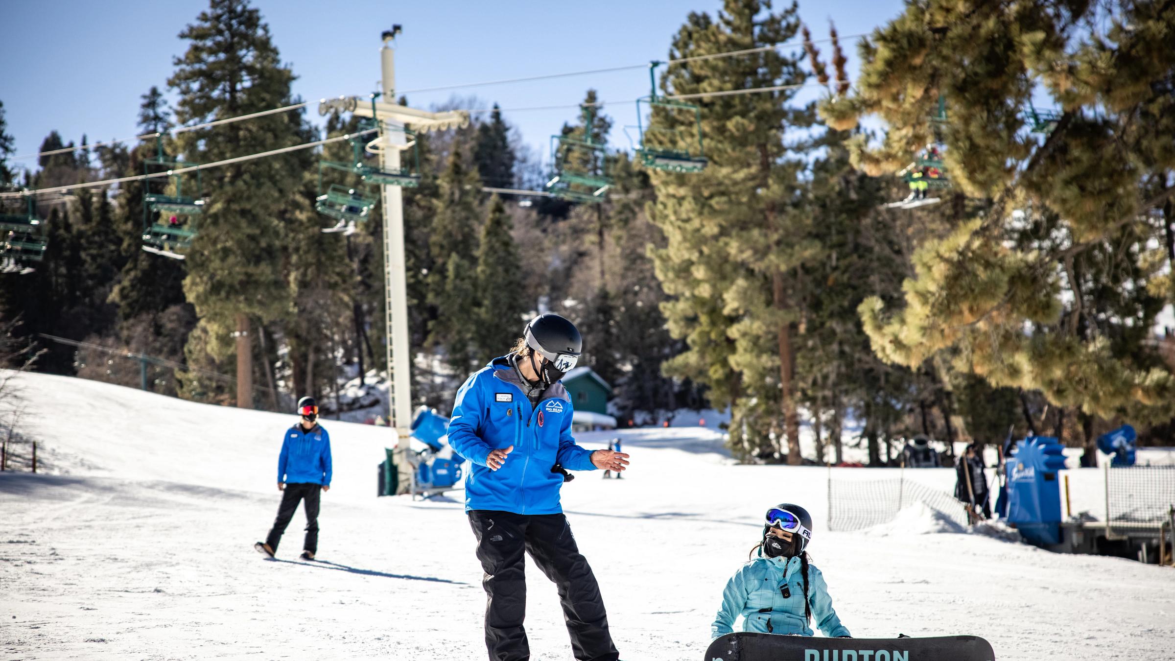 Girl taking a snowboard lesson