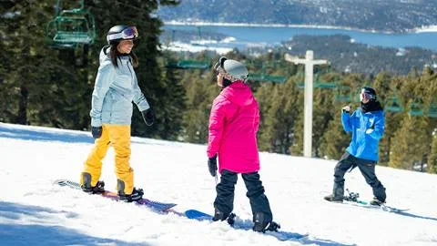 mother and daughter taking a snowboard lesson at snow summit