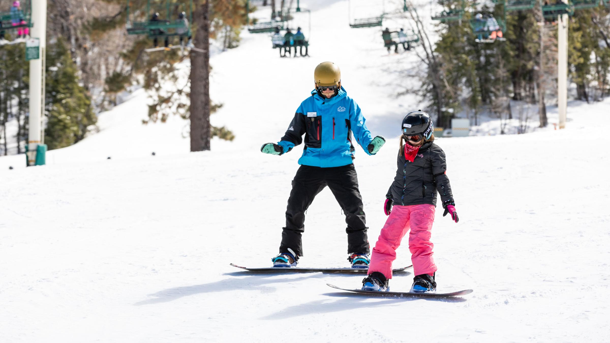 Young snowboarder taking a private lesson with instructor.