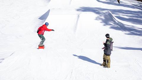 Snowboarder going down to a jump