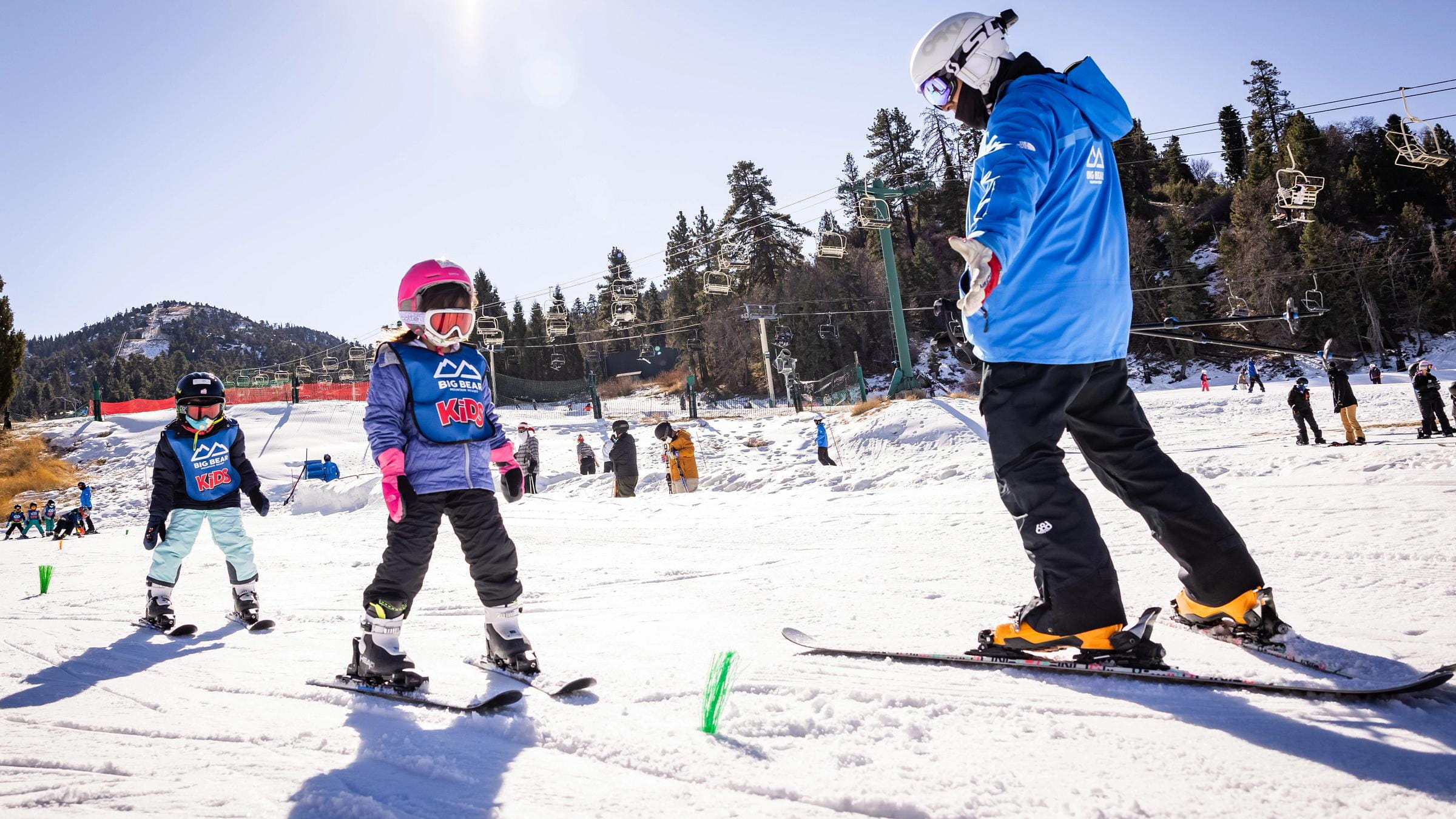 Two young kids taking a ski lesson.