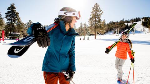 Mom and Daughter carrying skis to the slopes