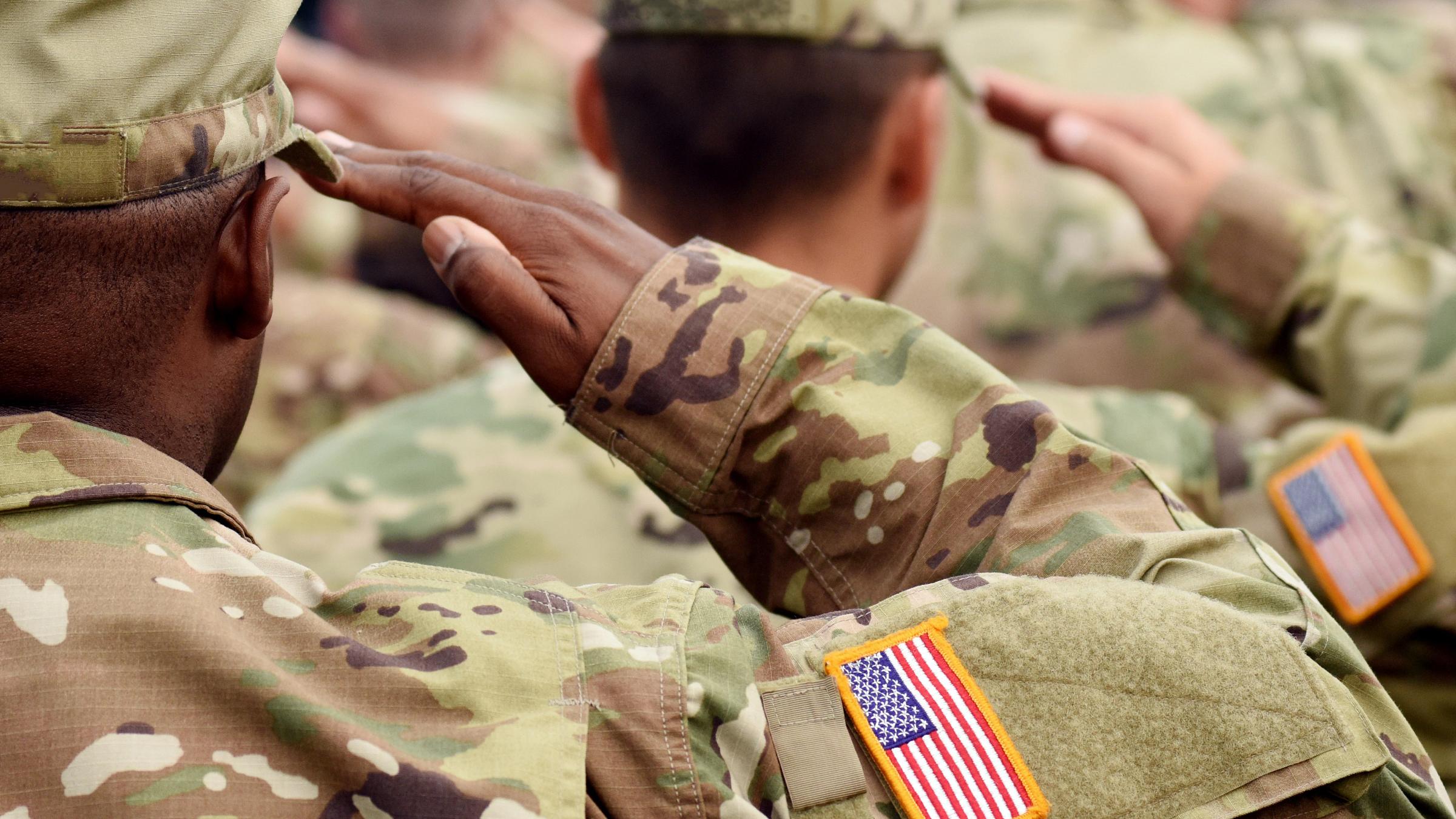 Soldiers in uniform saluting