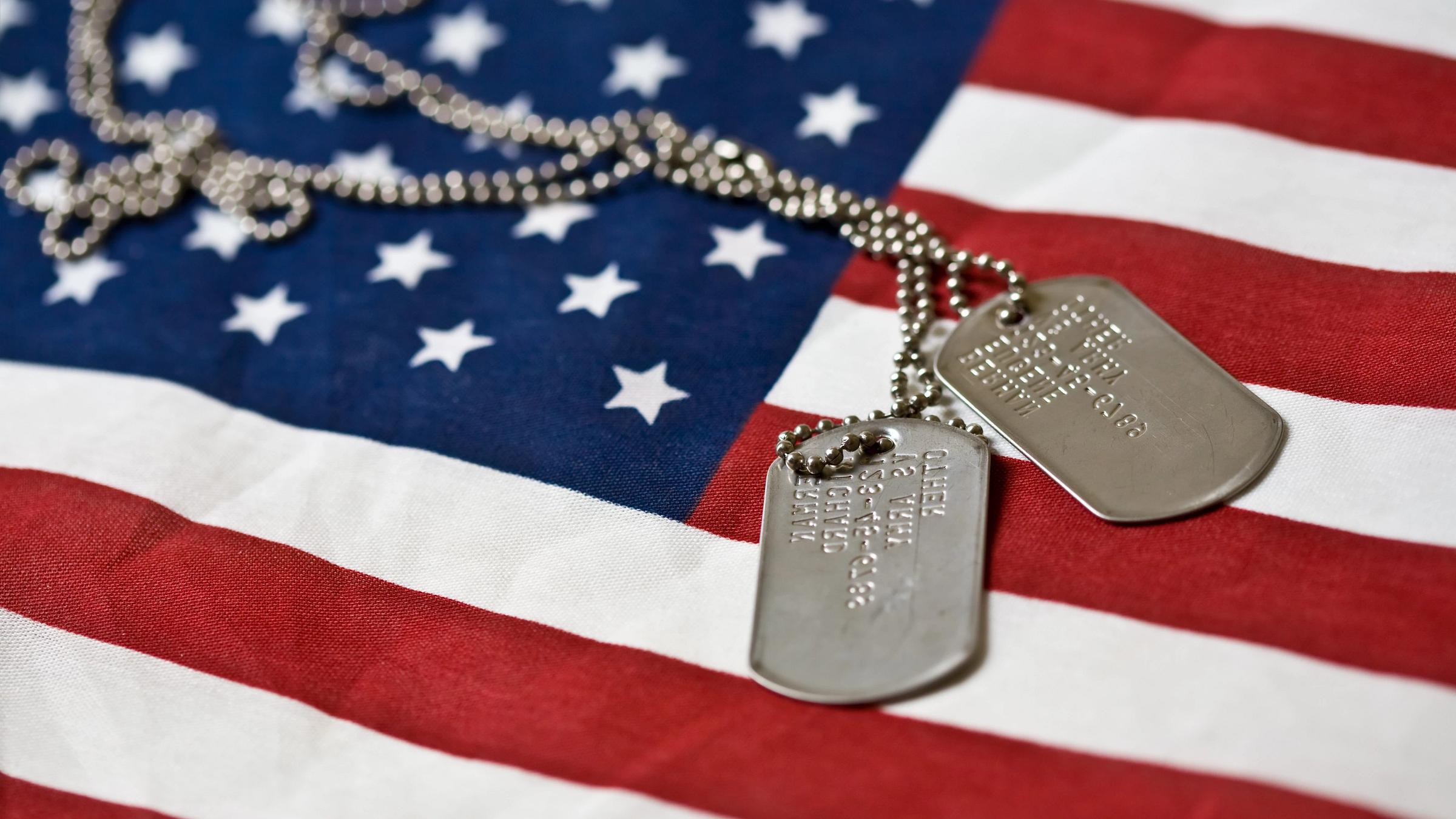 Military dog tags laying on American Flag