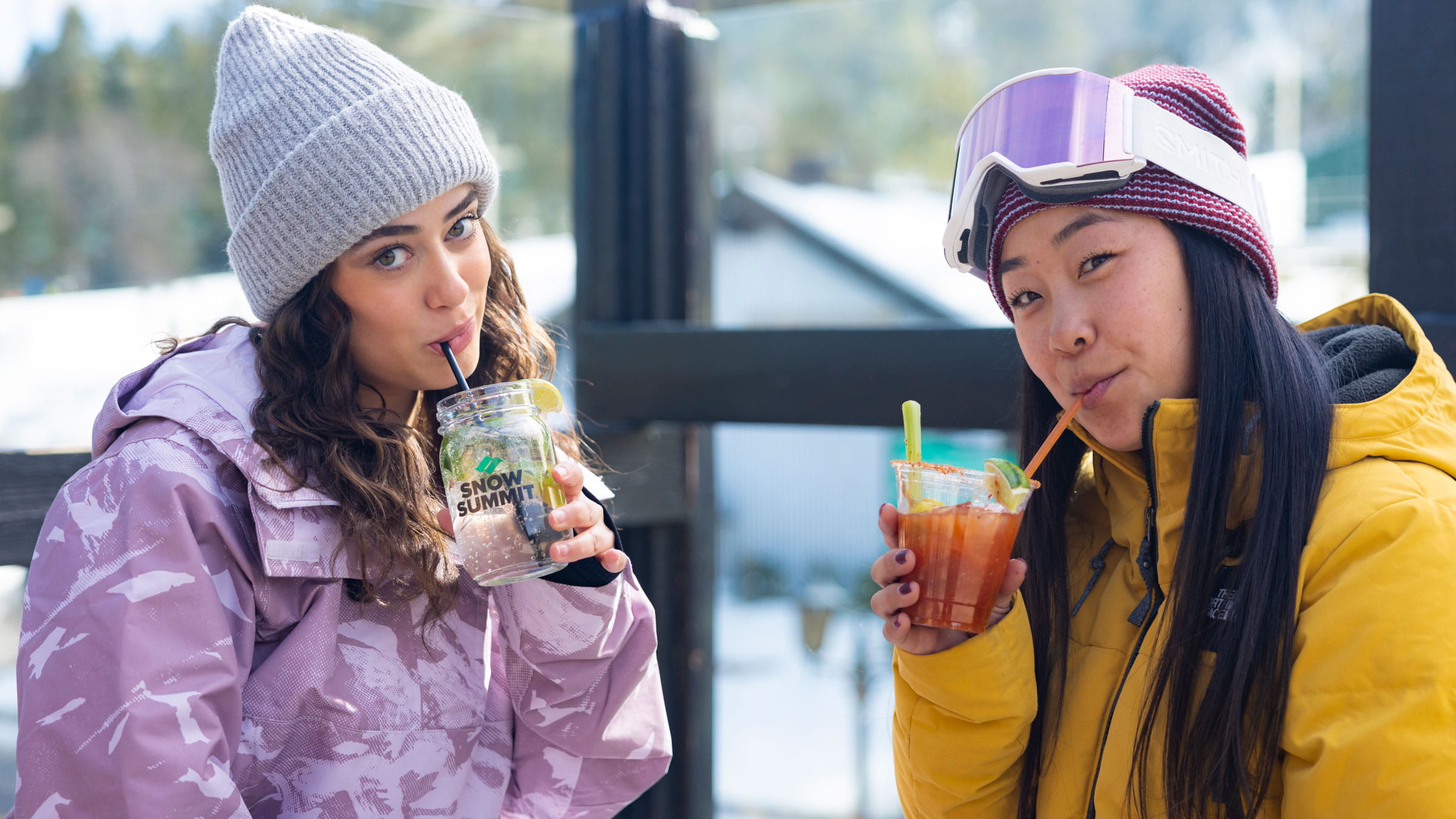 Two girls sipping on a cocktail wearing snowboarding gear at Snow Summit