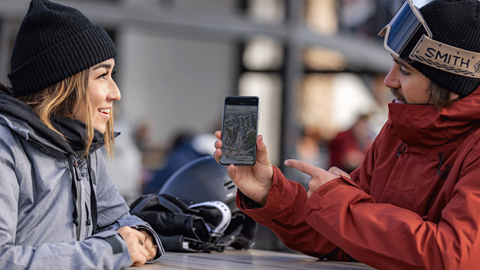 guy showing girl mobile app with a trail map on it
