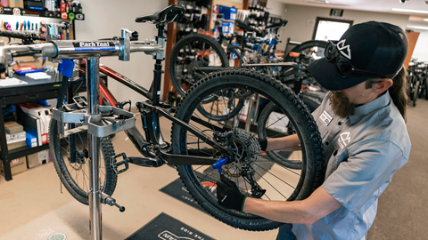 Bike mechanic working on fixing a bike at Snow Summit's repair shop