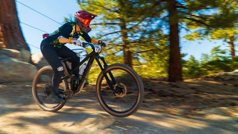 Mountain biker doing a jump trick on a mountain bike in the summertime at Snow Valley bike park