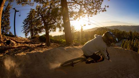 mountain biker riding downhill trails during sunset at snow valley bike park