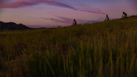 Twilight mountain biking session at snow valley bike park, pinkish-purple skies