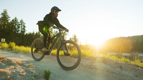 sun beaming through mountain biker during a sunset Twilight session at Snow Valley bike park