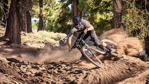 Mountain biker splashing dirt with bike wheels.