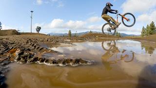 Reflection of a mountain biker in mud.