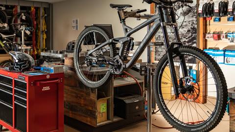 Black bike hanging on a bike rack