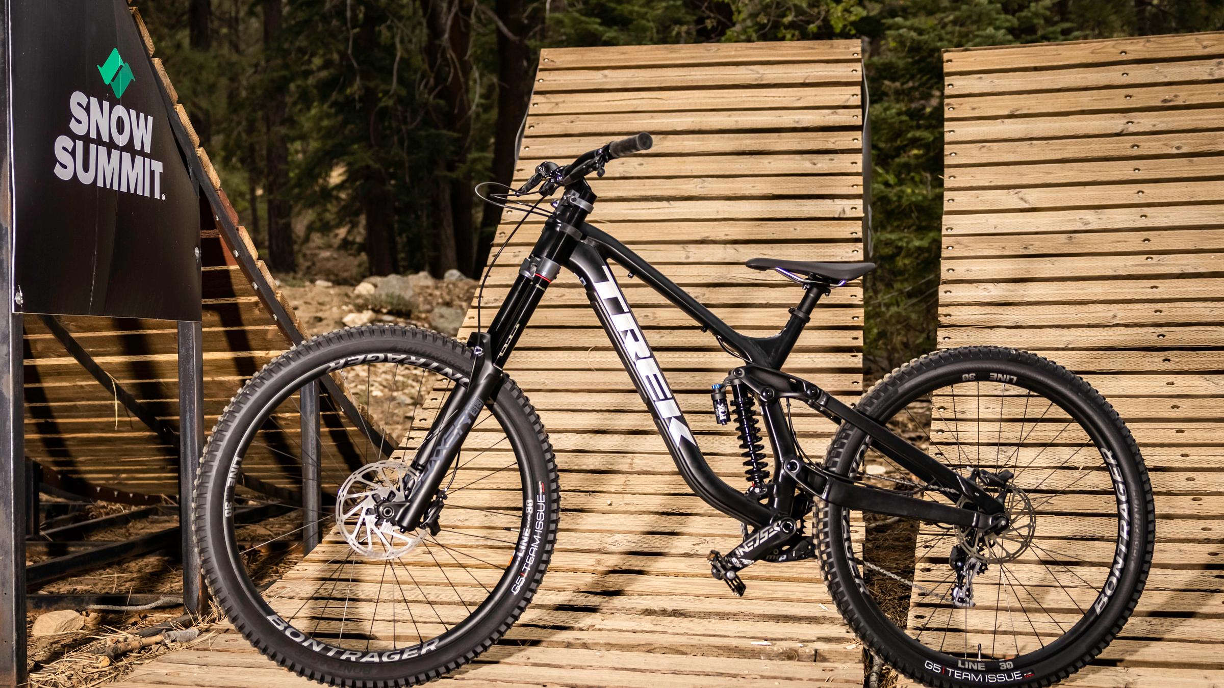 Black mountain bike sitting on a wooden ramp