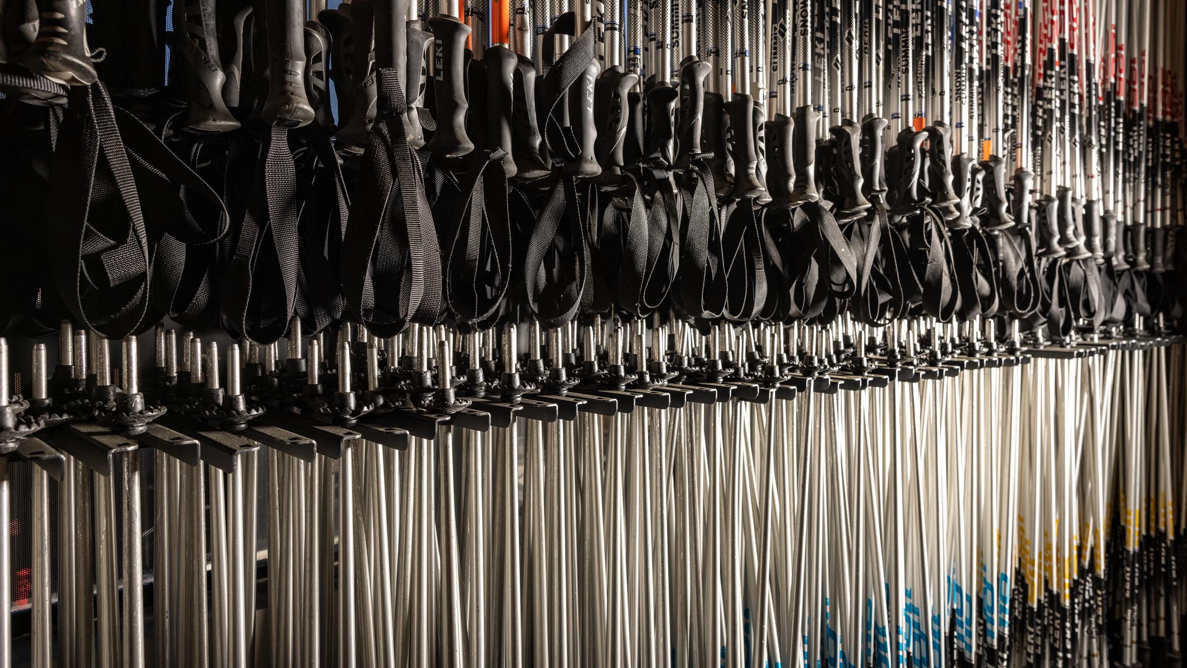 Ski poles hanging from a rack.