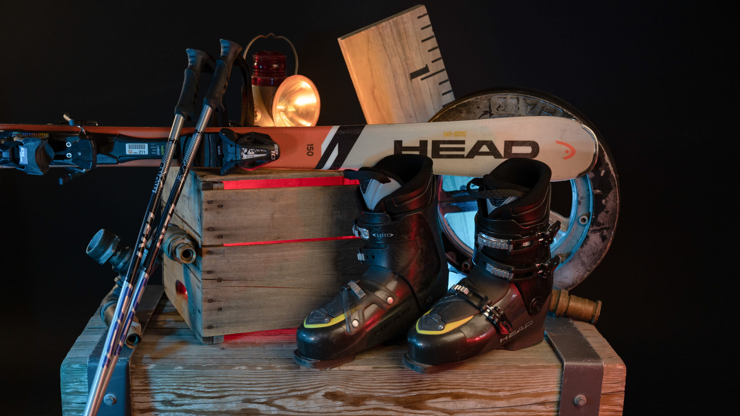 Ski boots, poles, and skis displayed upon a wooden box
