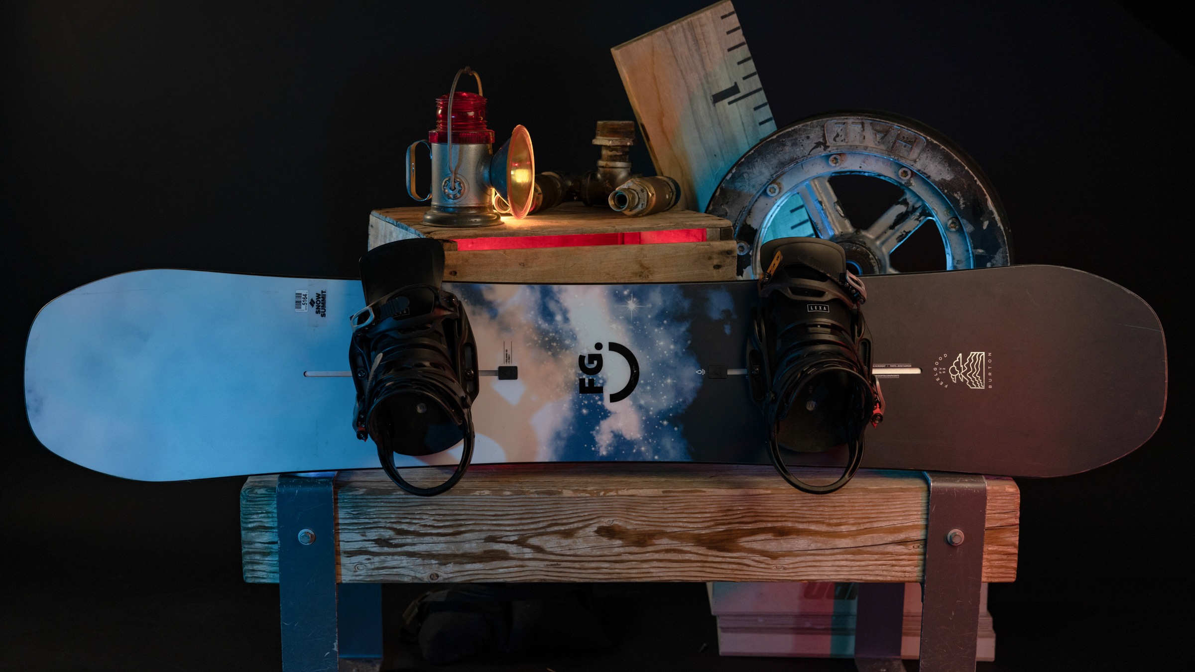 Snowboard with bindings displayed against wooden box
